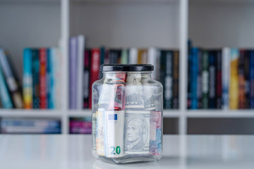 CHF usd us dollar euro € bills banknotes in glass jar on the white table at home money saving or investment business retirement concept