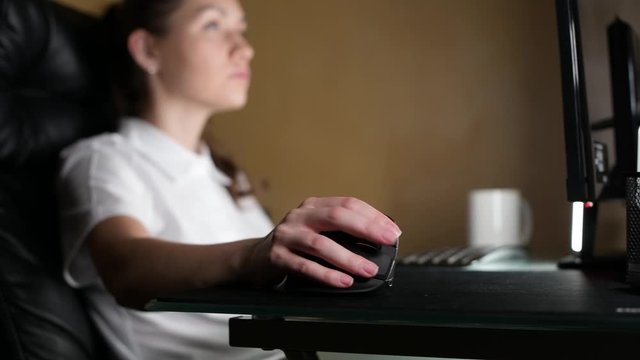 Girl businesswoman or designer working at night at a computer. Selective focus on the mouse. Series with one model.