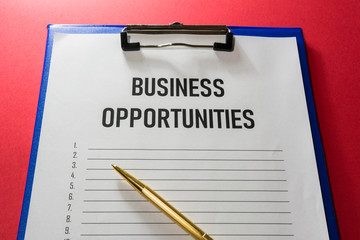Business opportunity text on white paper with list lines and a gilded pen, concept.