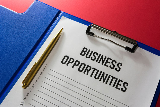 Business opportunity text on white paper with list lines and a gilded pen, concept.