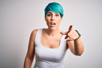 Young beautiful woman with blue fashion hair wearing casual t-shirt over white background pointing displeased and frustrated to the camera, angry and furious with you
