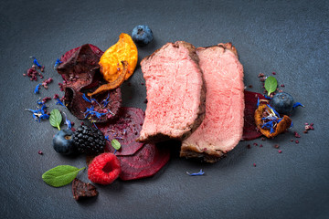 Barbecue dry aged wagyu roast beef natural sliced offered with vegetable chips and forest fruits as...