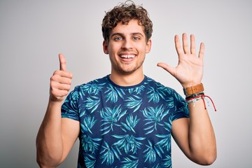 Young blond handsome man on vacation with curly hair wearing casual summer t-shirt showing and...