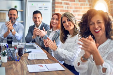Group of business workers smiling happy and confident. Working together with smile on face looking at the camera applauding at the office