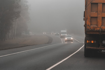 Driving car on heavy foggy day on country road. Poor visibility condition is dangerous for drivers.