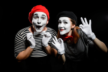 Cute mime artists on black. Waist up portrait of man and woman