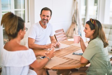 Beautiful family sitting on terrace drinking cup of coffee speaking and smiling