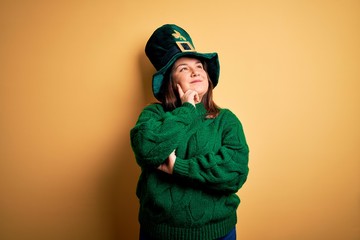 Young beautiful plus size woman wearing green hat with clover celebrating saint patricks day with...