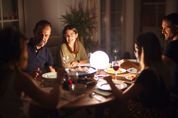 Beautiful family on dinner talking and smiling at terrace