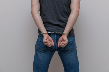 Adult prisoner male hands with handcuffs. Arrested man. Criminal concept.