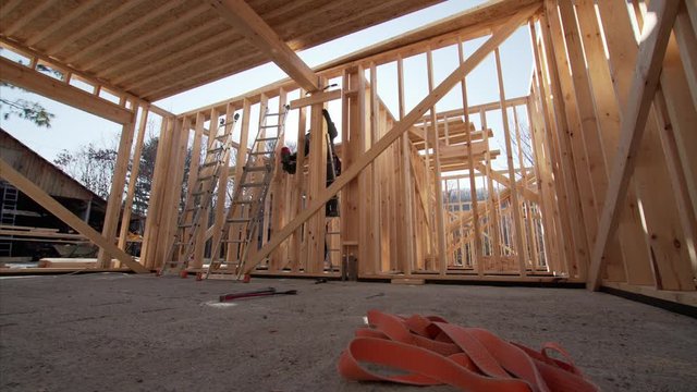 Timelapse of framer attaching beams with hydraylic hammer at frame house building