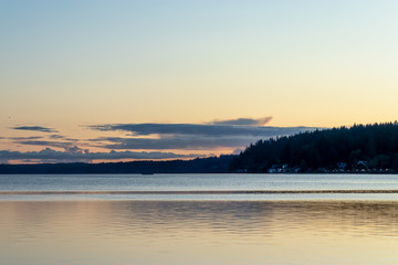 bright evening color over clouds and land near shoreline