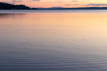 calm clean water of the puget sound with colorful sunset