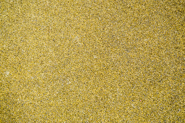 Yellow bright soft rubber flooring safe for sports and workout or on the playground from the many small round pebbles pressed. Background, texture