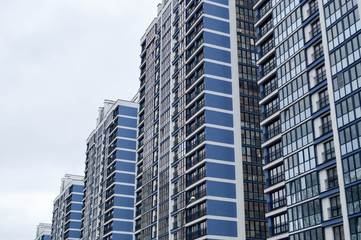 Naklejka premium New modern tall blue glass multi-storey comfortable urban monolithic frame houses buildings skyscrapers new buildings in the big city of the megalopolis