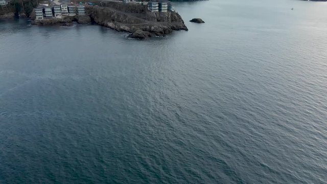 Aerial drone footage of the rugged Vancouver Island coastline near Sooke with a modern condo development atop a ocean view cliff. 4K 24FPS.