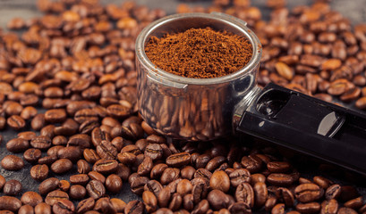 Ground coffee and coffee beans on old cafe table.