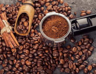 Ground coffee and coffee beans on old cafe table.