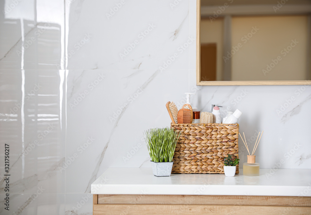 Sticker different toiletries and green plants on countertop in bathroom