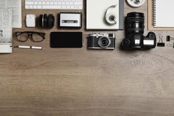 Flat lay composition with equipment for journalist on wooden table. Space for text