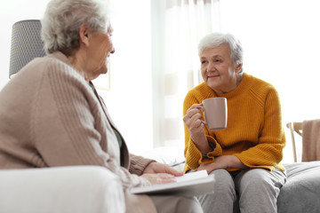 Elderly women spending time together in bedroom. Senior people care