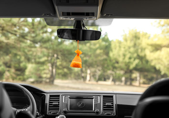 Air freshener hanging on rear view mirror in car
