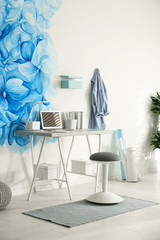 Stylish living room interior with blue flowers painted on wall. Floral pattern