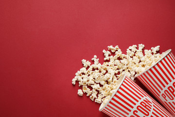 Flat lay composition with delicious popcorn on red background. Space for text