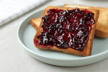 Delicious crispy toasts with jam on table, closeup