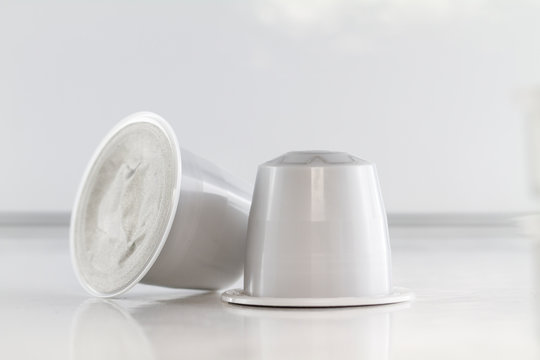 Close up on a coffee capsule resting on white background