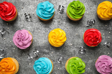 Obraz premium Flat lay composition with colorful birthday cupcakes on grey table