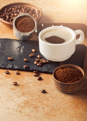 Ground coffee and coffee beans on old cafe table.