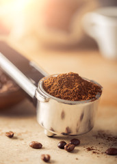 Ground coffee and coffee beans on old cafe table.