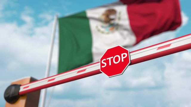 Closing boom barrier with stop sign against the Mexican flag. Restricted border crossing or certain ban in Mexico