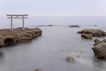 Oarai Japanese white shinto torii gate in a calm sea