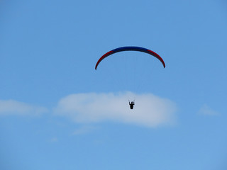 Paraglide flight in blue sky and some white clouds