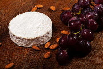 Fototapeta premium Camembert cheese or brie on wooden background
