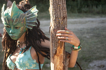 Beautiful tanned girl in the mask of an ancient goddess. The dancer shows movement. Mysterious girl...