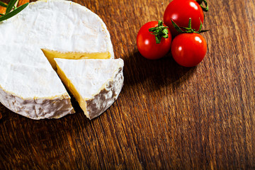 Camembert cheese or brie on wooden background