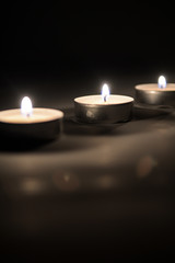 Small romantic candles against a dark background