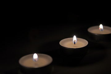 Small romantic candles against a dark background