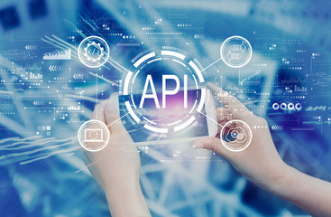 API - application programming interface concept API concept with person using a smartphone