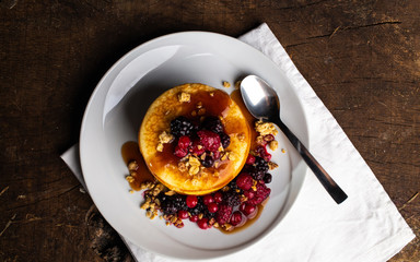 Top view of Pancakes with forest fruits berries on wooden table.Blueberries, raspberries on pancakes. Concept morning protein breakfast.