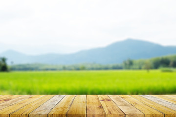 Shelf of Brown wood plank board with blurred green rice field farm with mountain and hut nature...