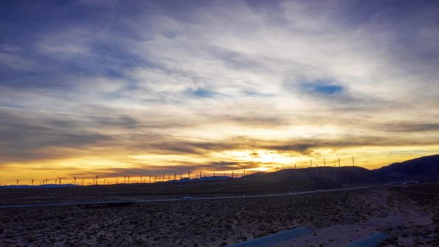 Beautiful Scenery Of Vehicles Driving On The Highway During Sunset In Red Rock Canyon In Las Vegas, Nevada With Silhouette Of Windmills In The Background - Timelapse