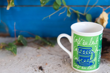 Green cup of coffee sitting on the ground