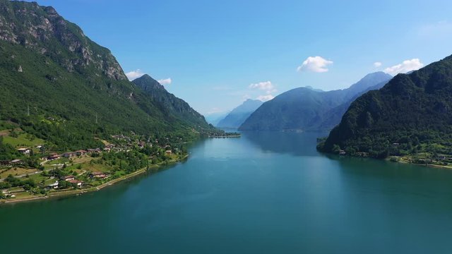Panoramic view of the mountains and Lake Idro. The reflection in the water of the mountains, trees, blue sky. Aerial view