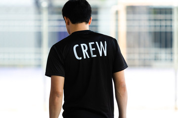 Back view of a young man wearing black CREW shirt
