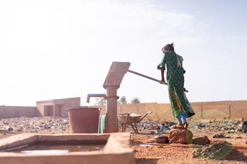 Joyful Native African Young Woman Carrying Healthy Water in a village