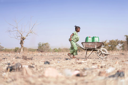 Little African Woman Transporting Fresh Water as a drought symbol